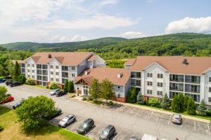 an aerial view of a apartment complex with a parking lot at White River Inn & Suites in White River Junction