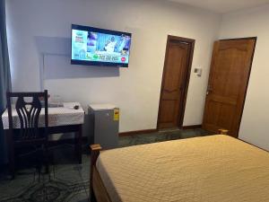 a room with a bed and a television on the wall at D Barfi Executive Lodge, excellent location in Kumasi