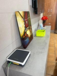 Un teléfono celular sobre un mostrador junto a un cuadro. en Casa mis Nietas, en San José