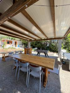 a wooden table and chairs under a pavilion at VillAGio in Solanas