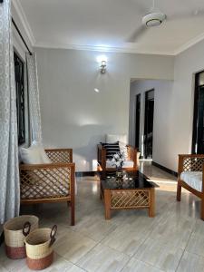 een woonkamer met stoelen en een salontafel bij Apartment 72 in Moshi