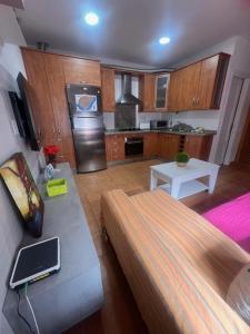 Una sala de estar con un sofá y una cocina. en Casa mis Nietas, en San José 11 fotos más