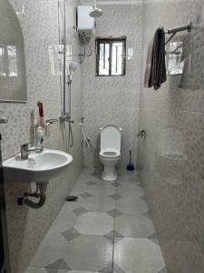 een badkamer met een toilet, een wastafel en een douche bij Apartment 72 in Moshi