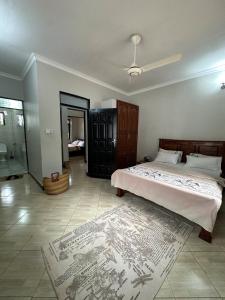 een slaapkamer met een groot bed en een tapijt bij Apartment 72 in Moshi