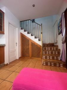 a room with a staircase and a pink rug at Casa mis Nietas in San José