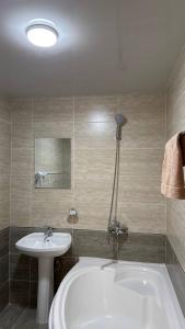 Un baño con bañera blanca y lavabo. en Sokin Palace, en Bukhara 18 fotos más