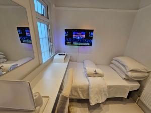 a small room with two beds and a mirror at The White House in Waltham Cross