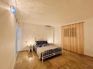 a bedroom with a bed in a room with a window at Dar Inès in Al Maqārisah