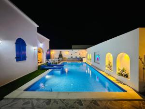 a swimming pool in a house at night at Dar Inès in Al Maqārisah +11 photos