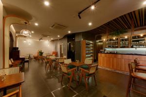 富国BayGi Phu Quoc Hotel的有桌椅和酒吧的餐厅