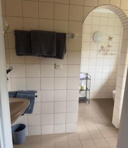 a white tiled bathroom with a sink and a mirror at Appartement Superior 6 in Ehrwald