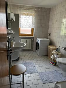 a bathroom with a sink and a washing machine at FeWo Feil nord in Freilassing