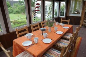 a table with plates on it in a room with windows at Ferienhaus in der Heide Barrierefrei, Rollstuhlgeeignet in Winsen Aller