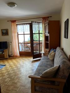 a living room with a couch and a large window at FeWo Feil nord in Freilassing