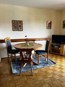 a dining room table with chairs and a television at FeWo Feil nord in Freilassing