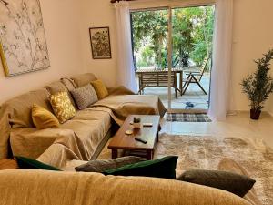 a living room with a couch and a table at The Garden & Pool Townhouse in Paphos
