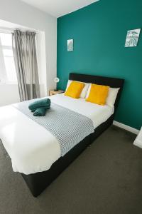 a bedroom with a large bed with yellow and blue walls at Cool Spot - Etihad - Coop Live in Manchester