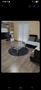 un soggiorno con un tavolo in vetro e un letto di Apartman Mona Liza, Bukvalek stari 1, a Banja Luka