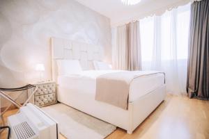 a white bedroom with a large bed and a window at Beograd na vodi - BW ViSTA LUXURY in Belgrade +48 photos