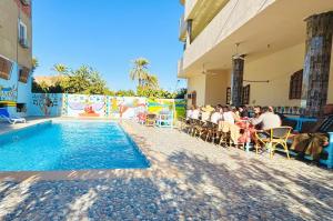 a group of people sitting in chairs by a swimming pool at Luxor Hotel in Luxor