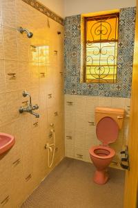 Un baño con un inodoro rosa y un lavabo. en Kajal guest house, en Calangute