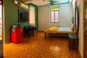 una habitación con una cama y una mesa y una ventana en Kajal guest house, en Calangute 17 fotos más
