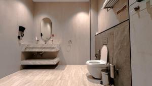 a bathroom with a toilet and a sink and a mirror at Grand Day Hotel Boutique in Al Hofuf