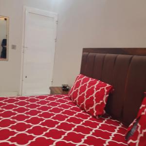 a bedroom with a red and white bed with two pillows at White Palace Guest House in Karachi +4 photos