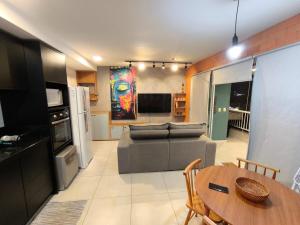 una cucina e un soggiorno con un divano e un tavolo di Apartamento 2 quartos Blumenau a 10 minutos da Vila Germânica a Blumenau
