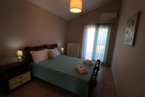 a bedroom with a bed with two slippers on it at Loukissia Villa Mare in Loukísia