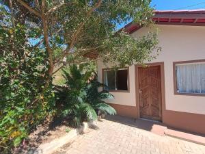a house with a tree and a door at Recanto da natureza em Anchieta in Anchieta