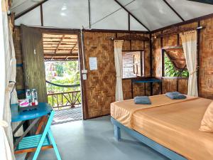 a bedroom with a bed in a room with a window at Bamboo Bungalows in Ko Phayam