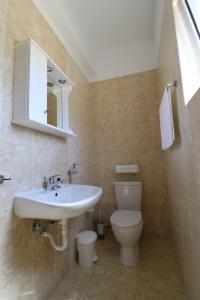 a bathroom with a white sink and a toilet at Loukissia Villa Mare in Loukísia +20 photos
