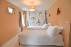 two white beds in a room with a window at La Maison Forestière in Lyons-la-Forêt