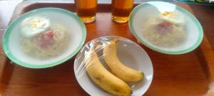 two bowls of food with a banana on a table at Bausasran52 in Yogyakarta