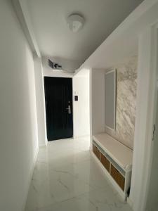 a hallway with a black door and a white wall at LCB Apartments G Enescu 19 in Suceava +1 photo