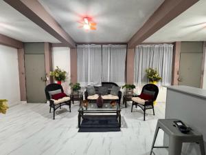 a living room with a couch and chairs at Hostal Genoveva in San Salvador