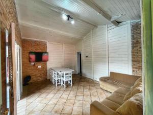 ein Wohnzimmer mit Sofa und Tisch in der Unterkunft Experience House Maresias in São Sebastião