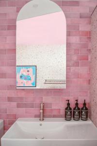 a pink tiled bathroom with a sink and a mirror at Fremantle Swan River Studio in East Fremantle +12 photos