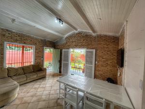 ein Wohnzimmer mit Sofa und Tisch in der Unterkunft Experience House Maresias in São Sebastião