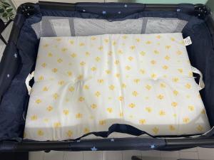 an open suitcase with a bed with yellow butterflies at Palace Yokohama New & Private in Yokohama
