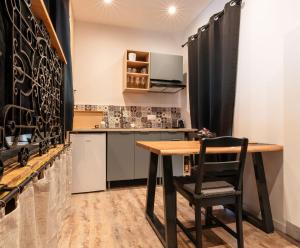 a kitchen with a wooden table and a black curtain at Love Room Troarn 70 m2 - La Discrète in Troarn