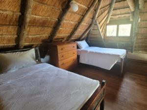 a bedroom with two beds and a dresser in a attic at Lush Horizons Game Lodge in Modimolle