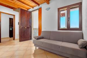 a living room with a couch and some windows at Villa Marianna - Almiddina in Telti