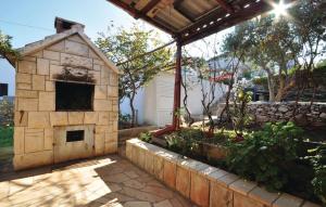 a brick oven in a yard with a stone wall at Apartment Natasa in Splitska