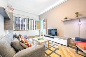 a living room with a couch and a tv at Lunin Apartments in Las Palmas de Gran Canaria