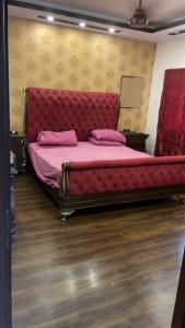 1 cama grande con cabecero rojo en una habitación en Heaven appartment, en Karachi