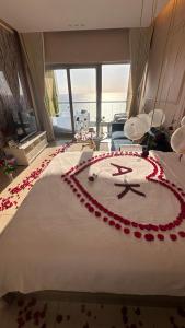 a bed with a clock made out of red roses at شقق بإطلالة بحرية في برج داماك جدة in Jeddah