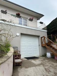 a garage with a white garage door and a balcony at Villa grain de sel in Étaples