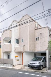 ein vor einem Gebäude geparktes Auto in der Unterkunft Familia Kamata 2 in Tokio